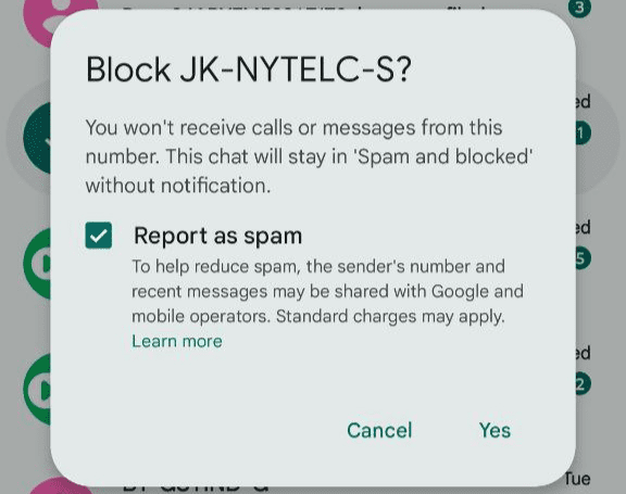 Android Messages confirmation dialog asking to block a sender, with the Report as spam option checked.