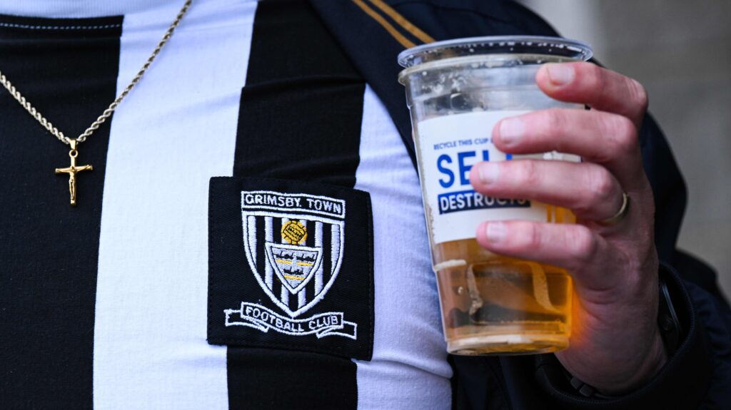 Grimsby football fan holds pint of beer